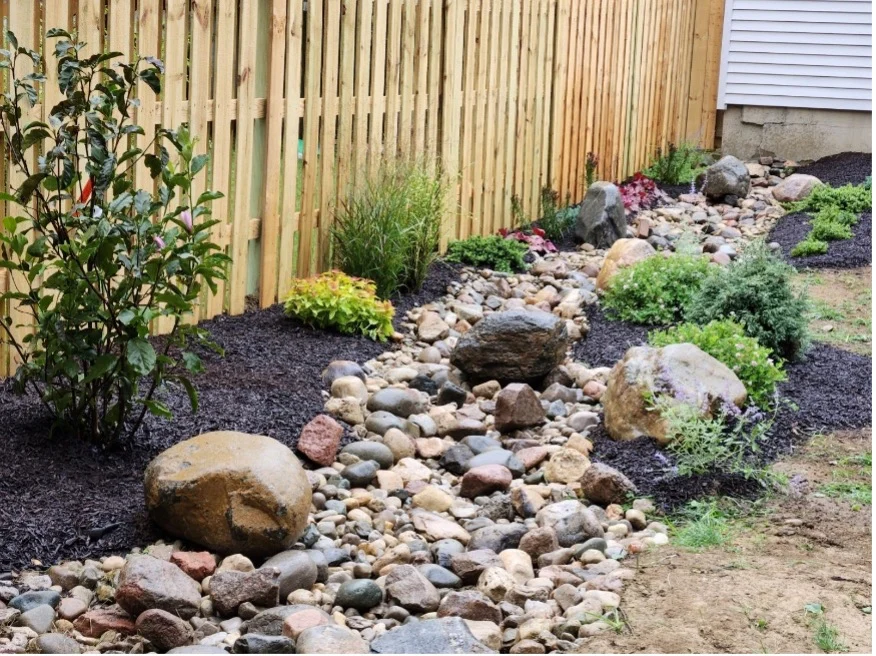 Decorative rock drainage feature with river stones and a dry creek bed solution in Cincinnati, Ohio